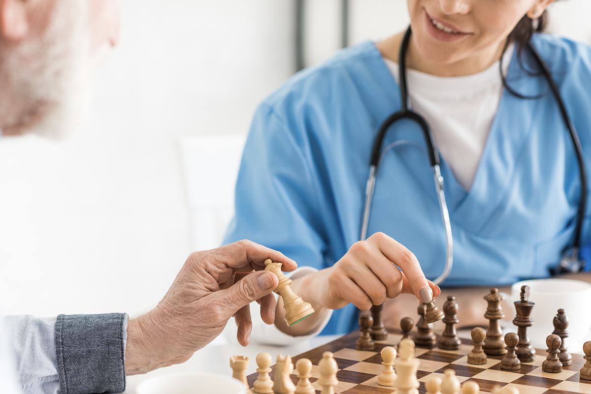 Ärztin spielt mit dem Patienten Schach